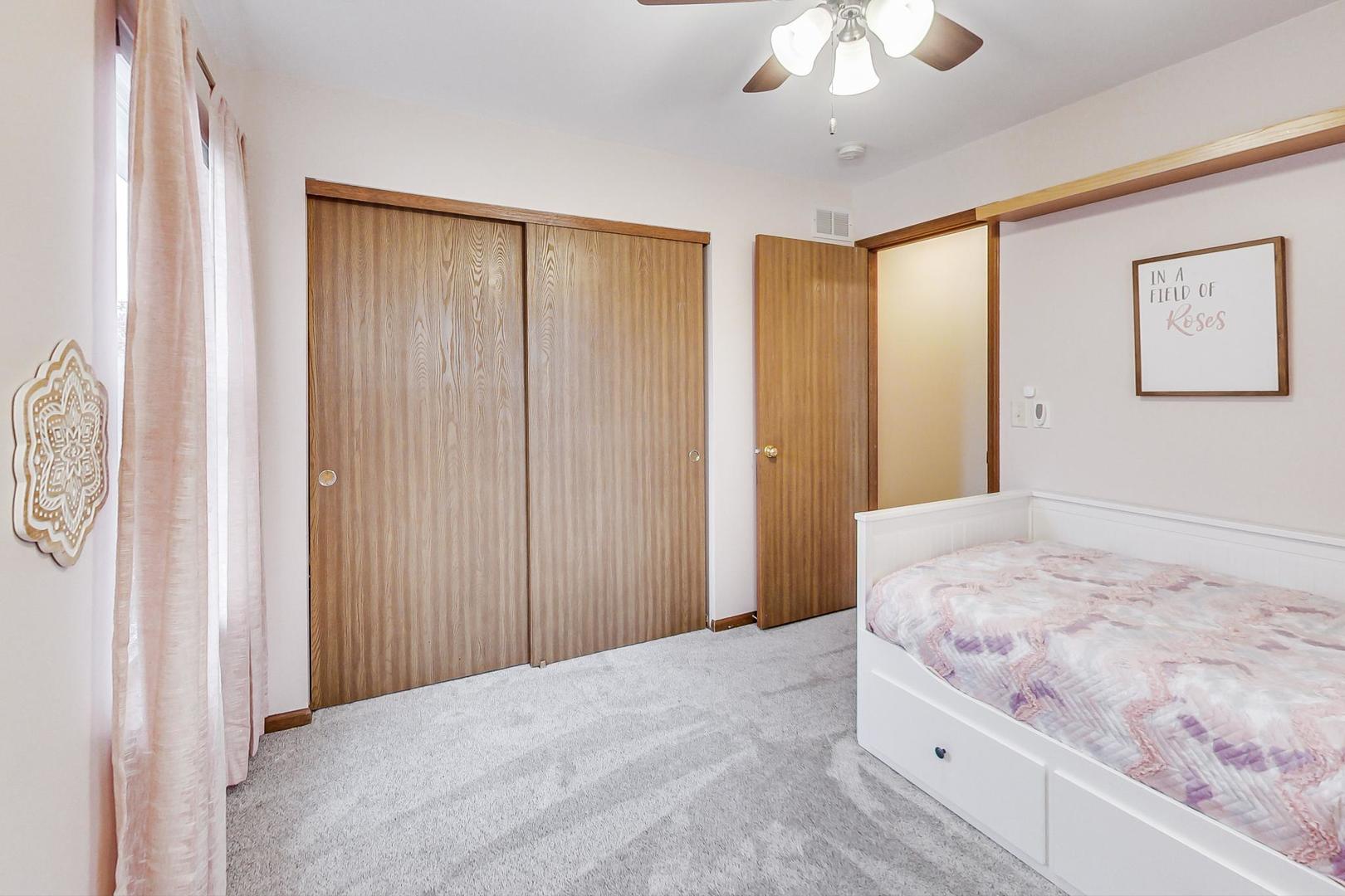 1174 Sweetwater Ridge Lake In The Hills, IL 60156 - Photo 21 of 44 a bedroom with a large bed and a chandelier