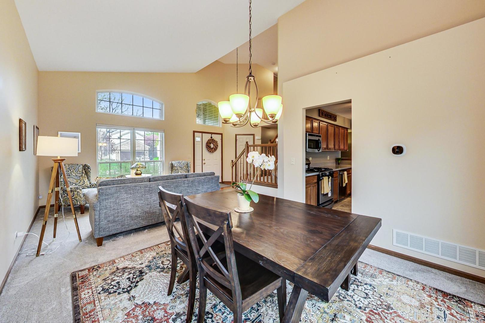 1174 Sweetwater Ridge Lake In The Hills, IL 60156 - Photo 7 of 44 a dining room with furniture and chandelier