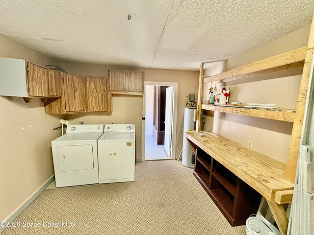 a view of washer and kitchen with stove