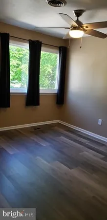 a view of a room with wooden floor and a window