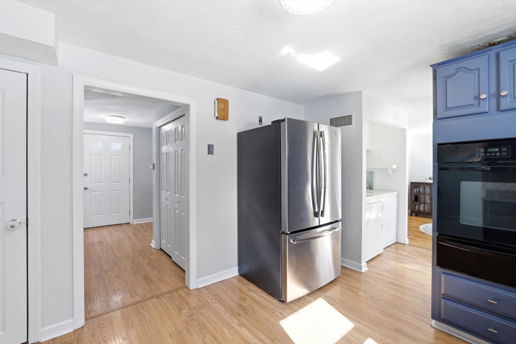 46 Brookwood Road Hanover, MA 02339 - Photo 10 of 41 a view of a kitchen with a refrigerator a stove top oven and cabinets
