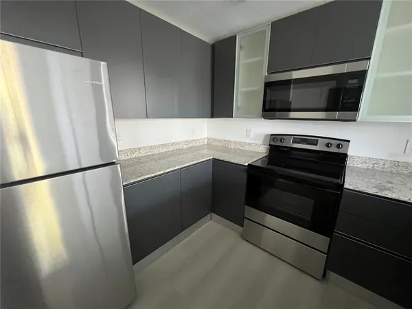 a kitchen with a refrigerator and a stove