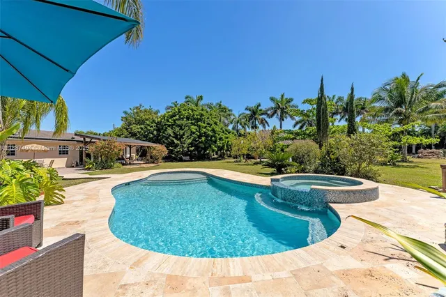 a swimming pool with outdoor seating and yard