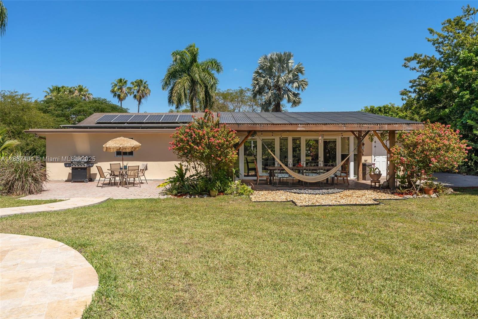 20230 Southwest 184th Street Miami, FL 33187 - Photo 23 of 42 rear view of the home w/ covered patio located off Florida Room features custom wood columns ideal for hanging hammock.. in addition the property has solar!