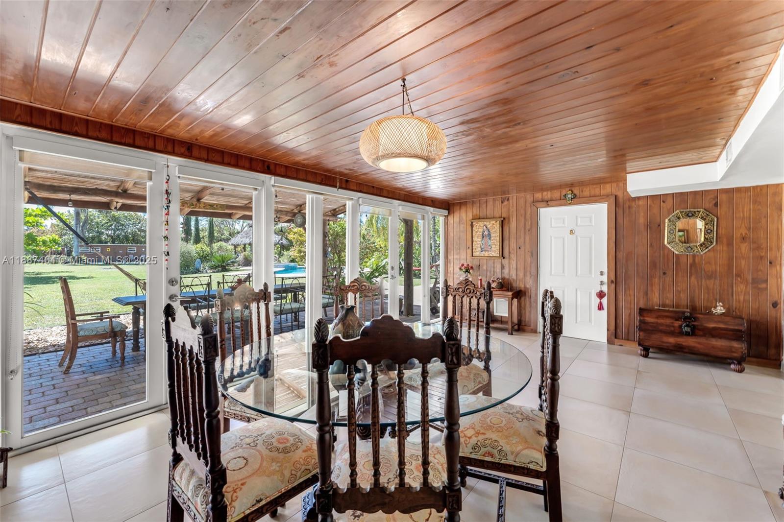 20230 Southwest 184th Street Miami, FL 33187 - Photo 9 of 42 the Florida room overlooks the amazing property. the cabana suite door seen in photo has additional access from an exterior private entrance. ideal for overnight guests. current use is dining room.