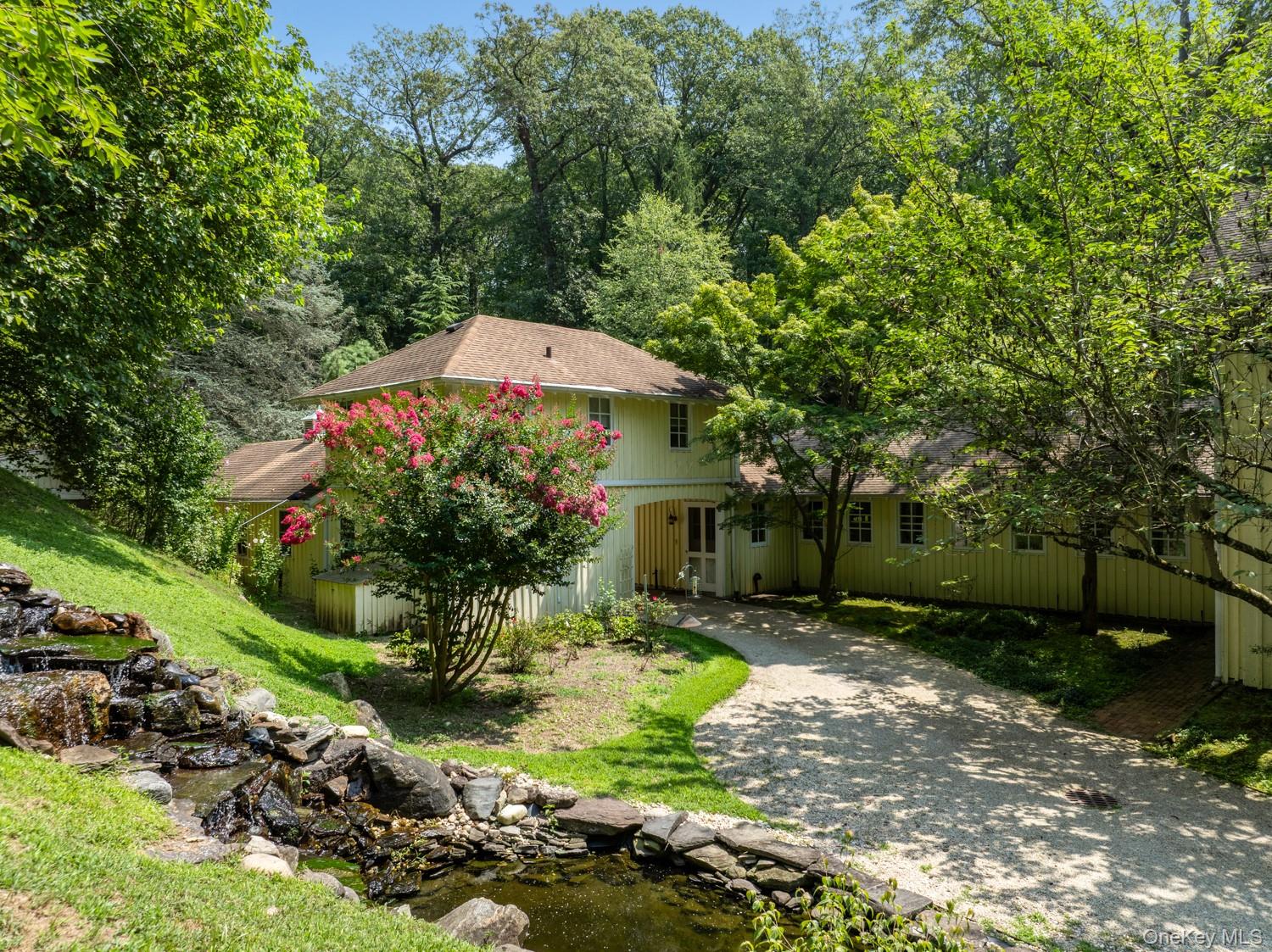 62 Cove Neck Road Cove Neck, NY 11771 - Photo 22 of 25 View of front facade with driveway, a garden pond, and a shingled roof