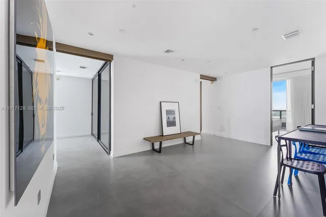 a view of a hallway with a livingroom and furniture