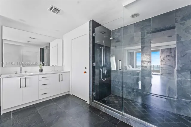 a bathroom with a shower sink and mirror