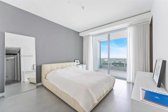 a bedroom with a bed and large glass window