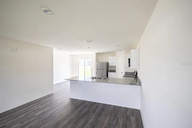 a bathroom with a granite countertop sink a toilet and shower