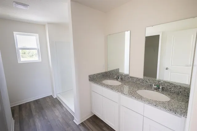 a bathroom with a granite countertop sink and a mirror