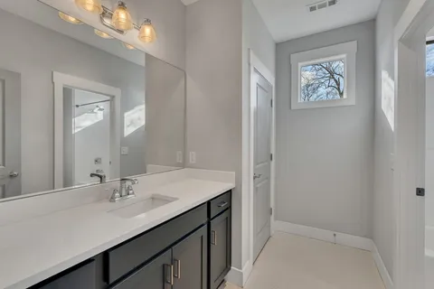 a bathroom with a sink vanity and a mirror