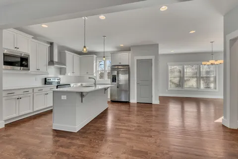 a kitchen with stainless steel appliances a refrigerator sink and microwave