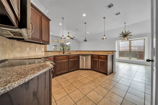 a kitchen with stainless steel appliances granite countertop a sink stove and cabinets