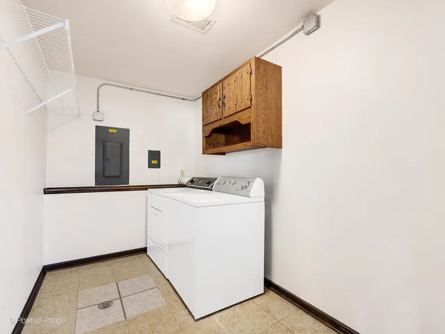 a utility room with cabinets washer and dryer