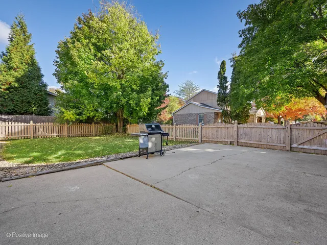 a view of backyard with wooden fence and trees