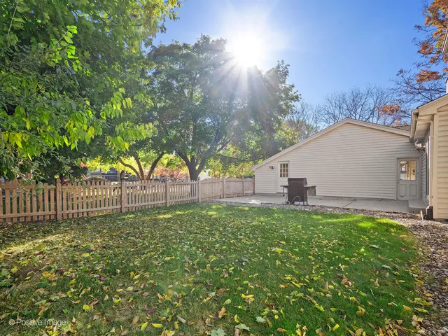 a view of backyard with tree and wooden fence