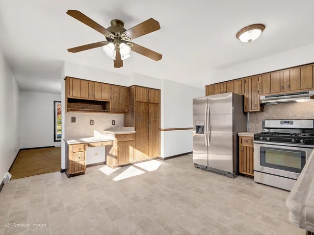 a kitchen with stainless steel appliances a stove a refrigerator and a refrigerator