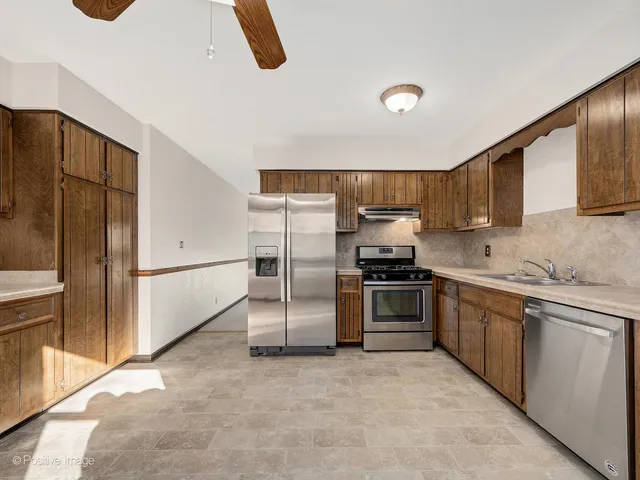 a kitchen with stainless steel appliances granite countertop a refrigerator and a stove top oven