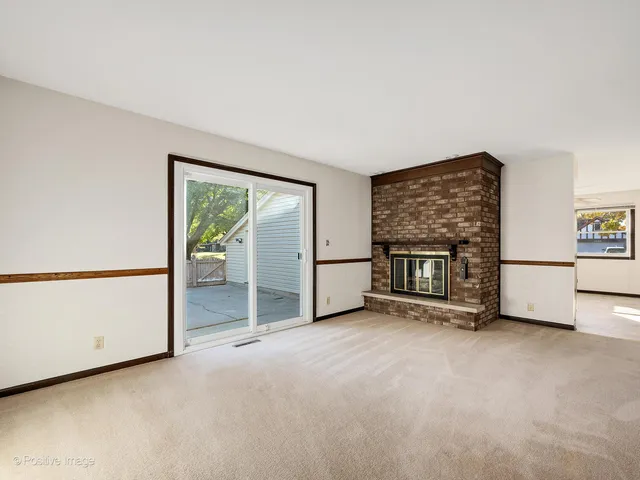 a view of an empty room with a fireplace and a window
