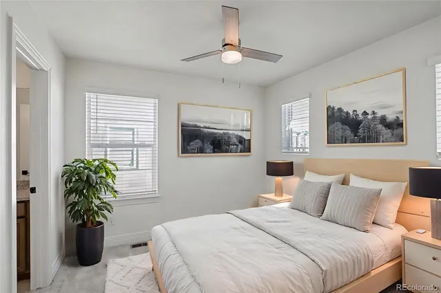 a bedroom with a large bed and a potted plant