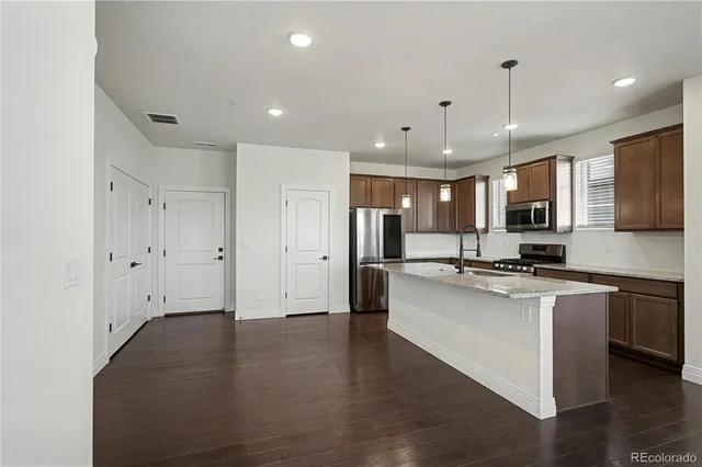 a large kitchen with stainless steel appliances lots of counter space and a sink