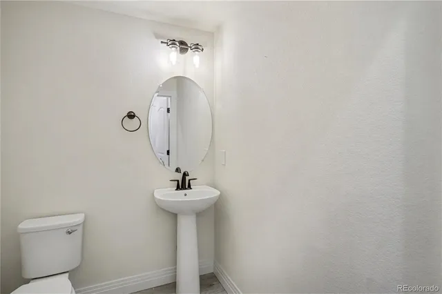 a bathroom with a sink a mirror and toilet