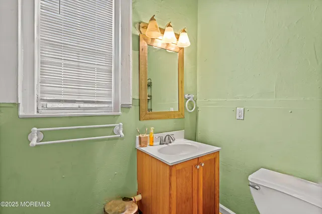 a bathroom with a sink a toilet and mirror