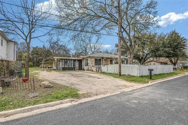 a view of a house with a yard and large trees