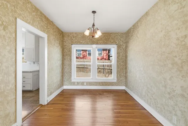 a view of a hallway with wooden floor and a living room