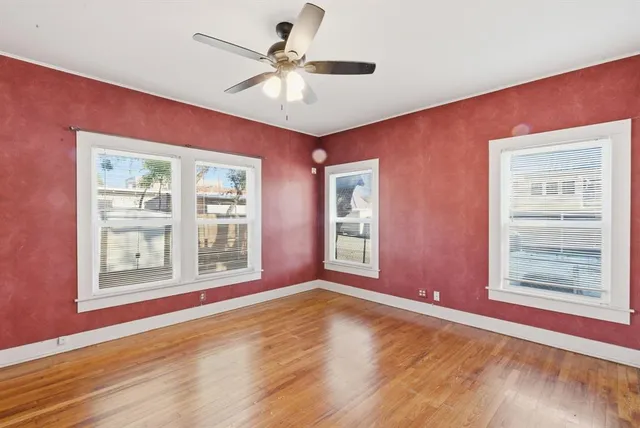 a view of an empty room with a window and a kitchen view