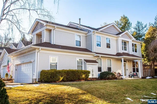 a view of a white house with a big yard and large trees