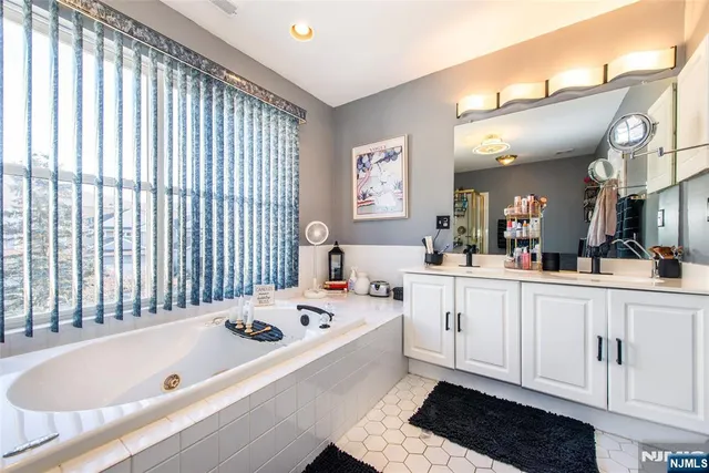 a large white tub sitting in a bathroom next to a window