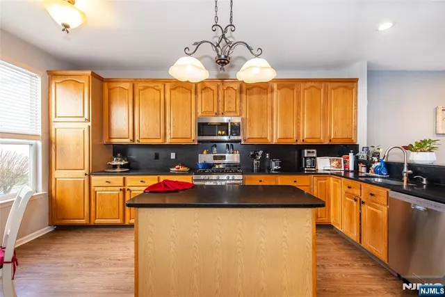 a kitchen with kitchen island granite countertop a stove and a sink