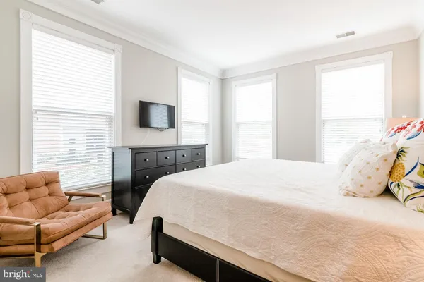 a bedroom with a bed a couch and a flat screen tv