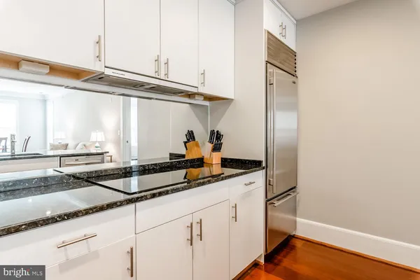 a kitchen with stainless steel appliances granite countertop a sink and a white cabinets