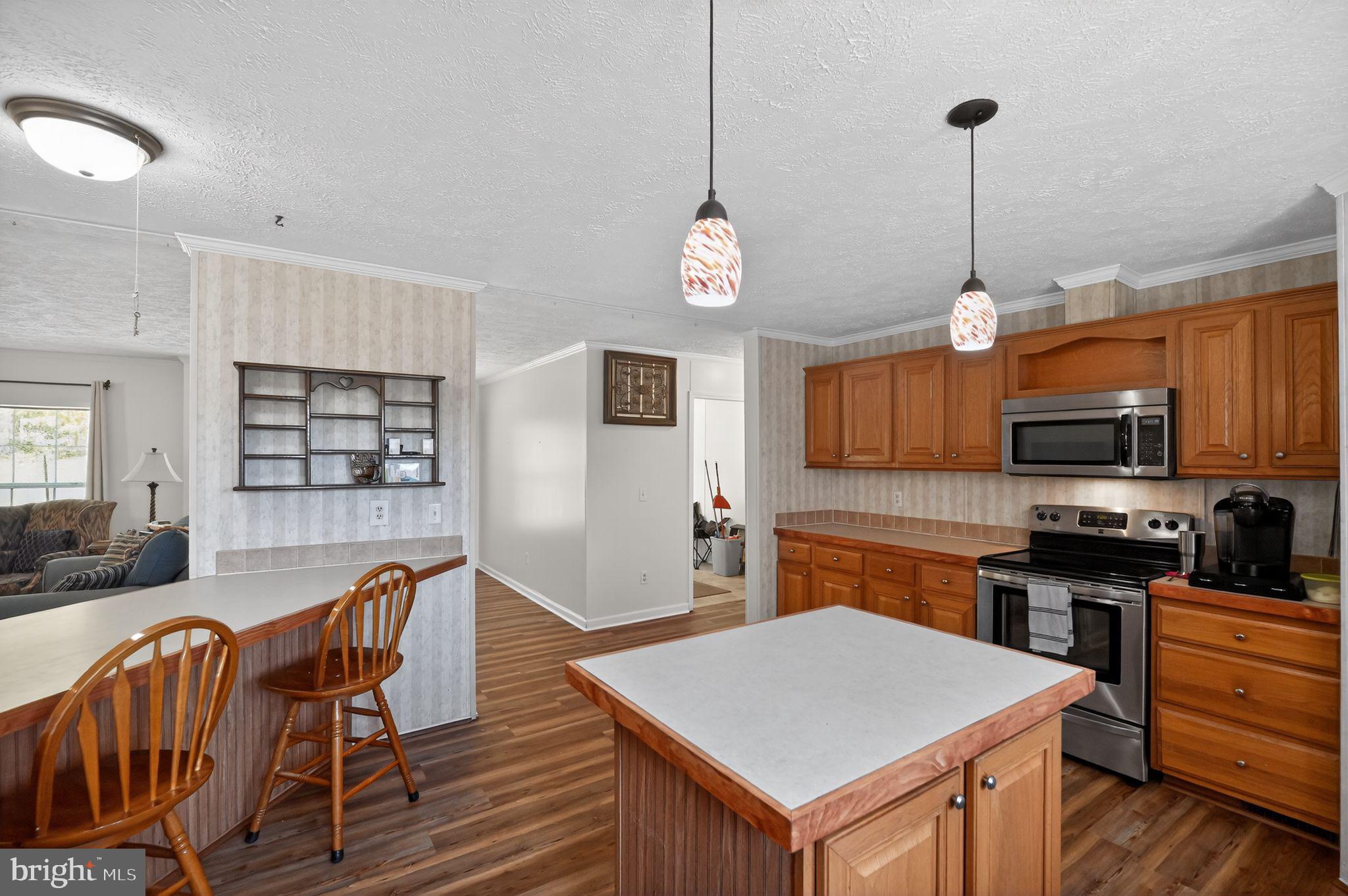 178 Lizzie Mills Road Castleton, VA 22716 - Photo 25 of 40 a open kitchen with stainless steel appliances granite countertop a stove top oven a refrigerator a sink a dining table and chairs with wooden floor
