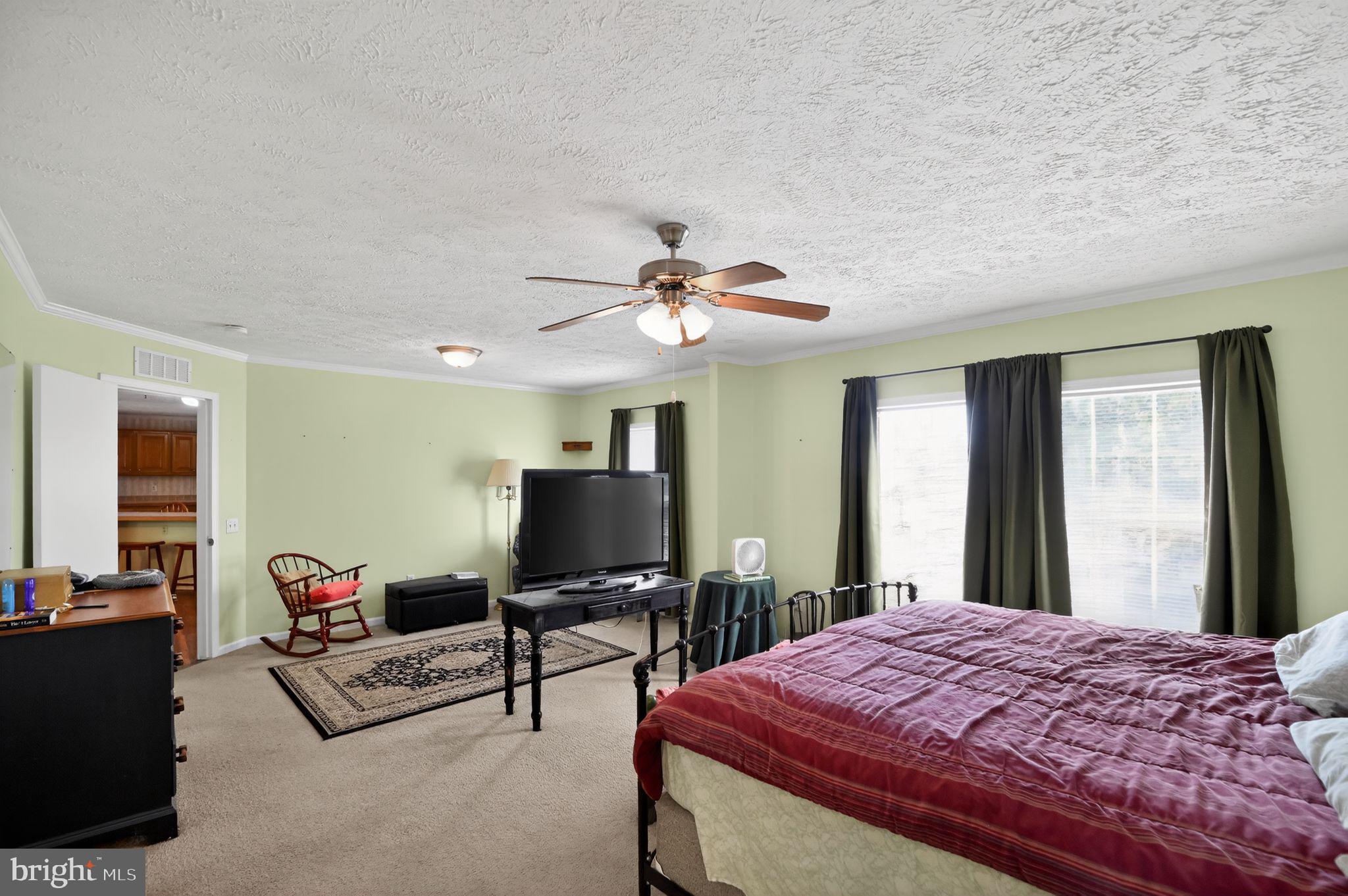 178 Lizzie Mills Road Castleton, VA 22716 - Photo 34 of 40 a bedroom with a bed and a chandelier