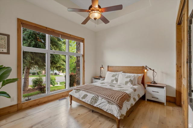 4892 Eagle Rdg Drive Eden, UT 84310 - Photo 16 of 39 Spacious room featuring a large multi-pane window with wood trim, wood-finish flooring, a tray ceiling, and a ceiling fan with integrated lighting