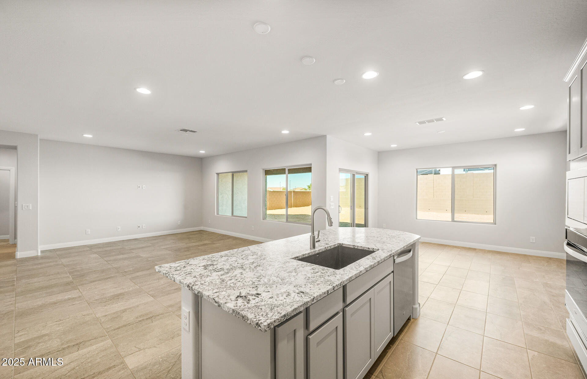 6694 West Ripken Way Florence, AZ 85132 - Photo 16 of 37 a kitchen with stainless steel appliances granite countertop a sink and a white cabinets