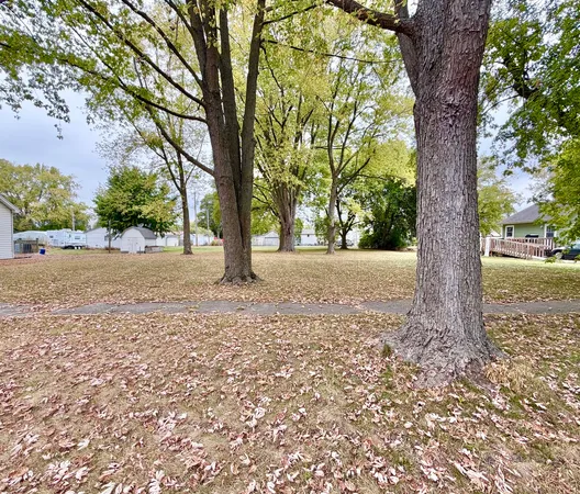 a view of backyard with large trees and plants