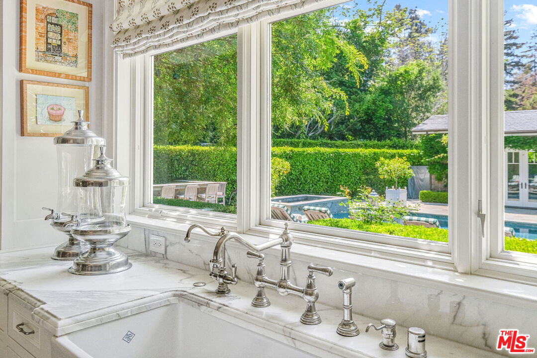 14100 Rustic Lane Pacific Palisades, CA 90272 - Photo 11 of 46 a bathroom with a granite countertop sink and a large window