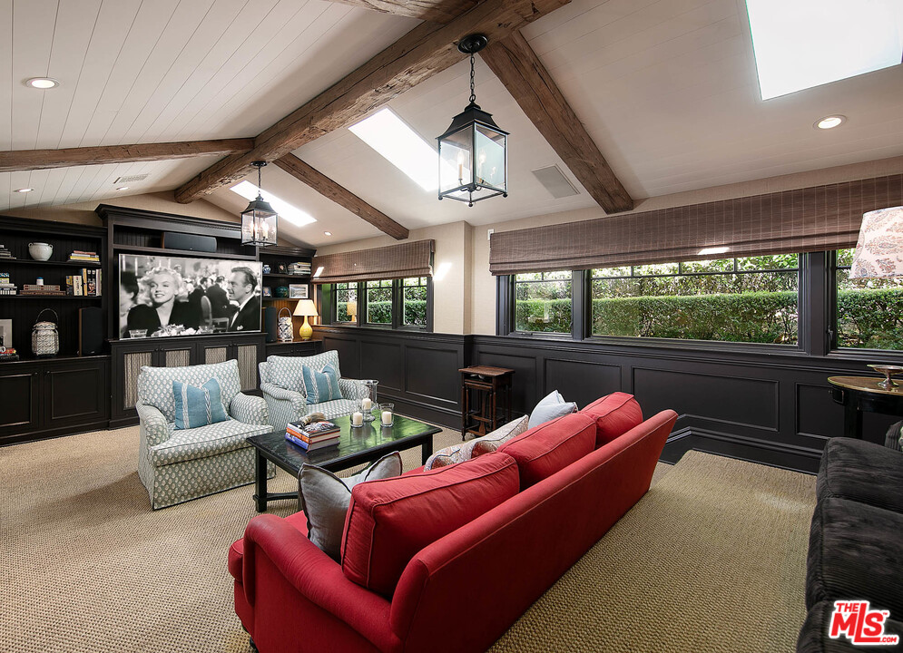 14100 Rustic Lane Pacific Palisades, CA 90272 - Photo 14 of 46 a living room with furniture a ceiling fan and a floor to ceiling window
