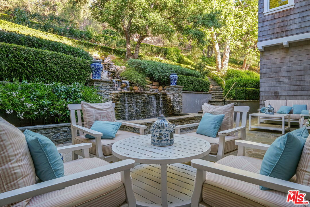 14100 Rustic Lane Pacific Palisades, CA 90272 - Photo 17 of 46 a view of a patio with couches table and chairs and potted plants