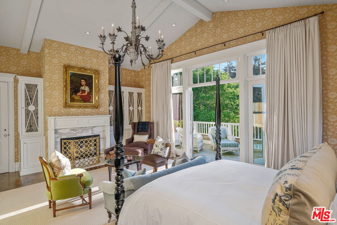 14100 Rustic Lane Pacific Palisades, CA 90272 - Photo 22 of 46 a spacious bedroom with a bed and a chandelier