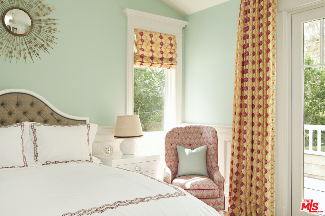 14100 Rustic Lane Pacific Palisades, CA 90272 - Photo 27 of 46 a bedroom with a bed lamp and a large window