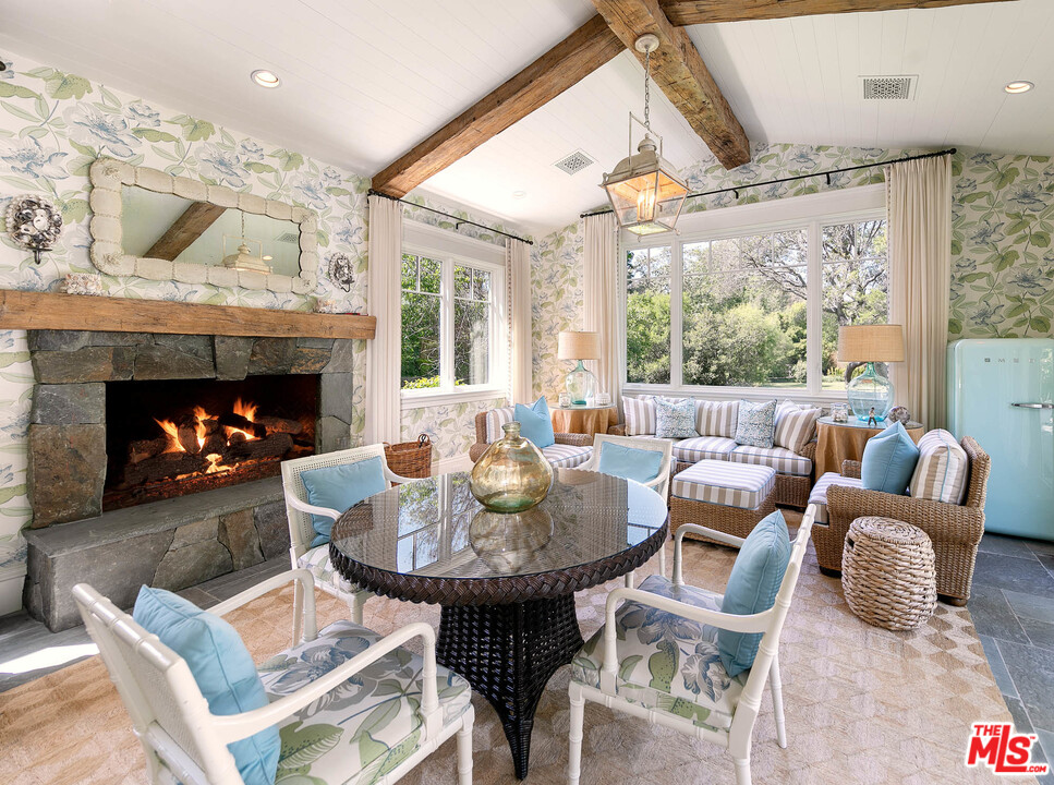 14100 Rustic Lane Pacific Palisades, CA 90272 - Photo 30 of 46 a living room with furniture a fireplace and a large window