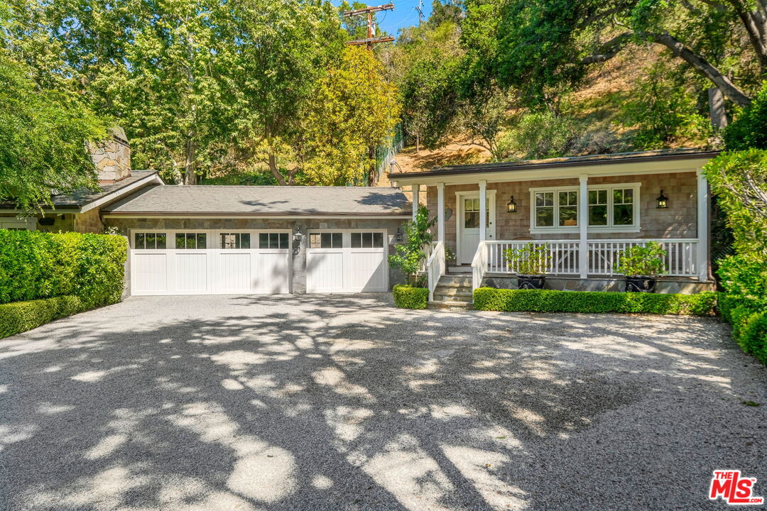 14100 Rustic Lane Pacific Palisades, CA 90272 - Photo 32 of 46 a front view of a house with a garden