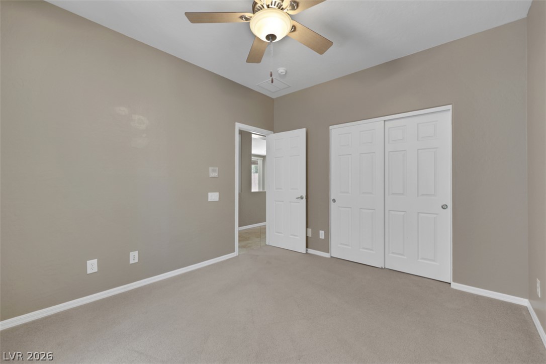 2501 Bechamel Place Henderson, NV 89044 - Photo 18 of 50 A comfortable bedroom with vaulted ceilings, featuring a practical ceiling fan and ample closet space.