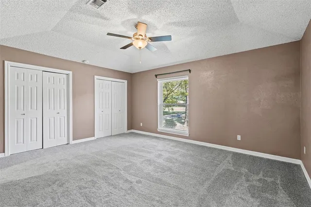 an empty room with closet and fan